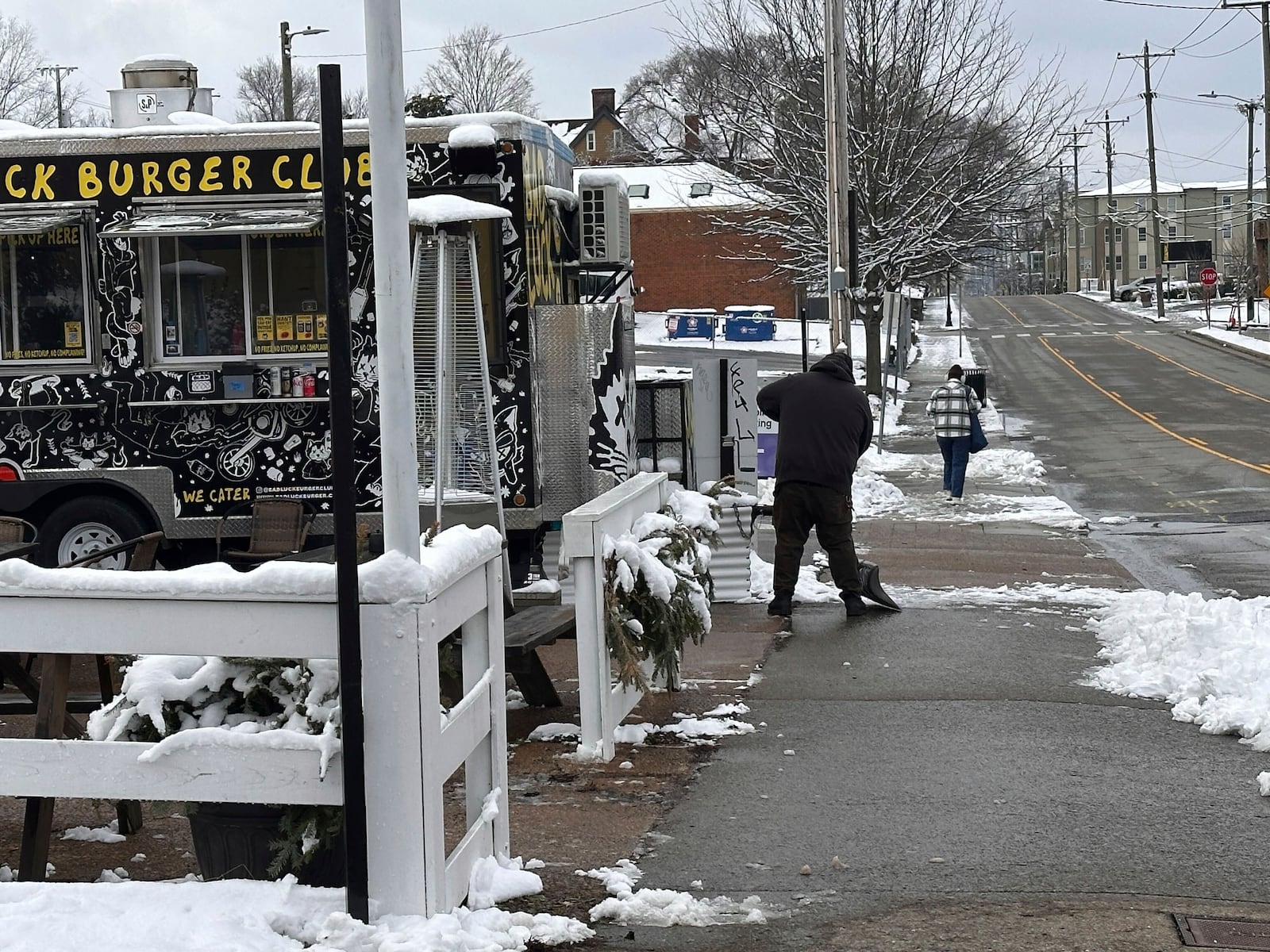 Andy Atkins removes snow from the outdoor seating area for his food truck Bad Luck Burger Club in Nashville, Tenn. on Saturday, Jan.11, 2025. (AP Photo/Kristin M. Hall)