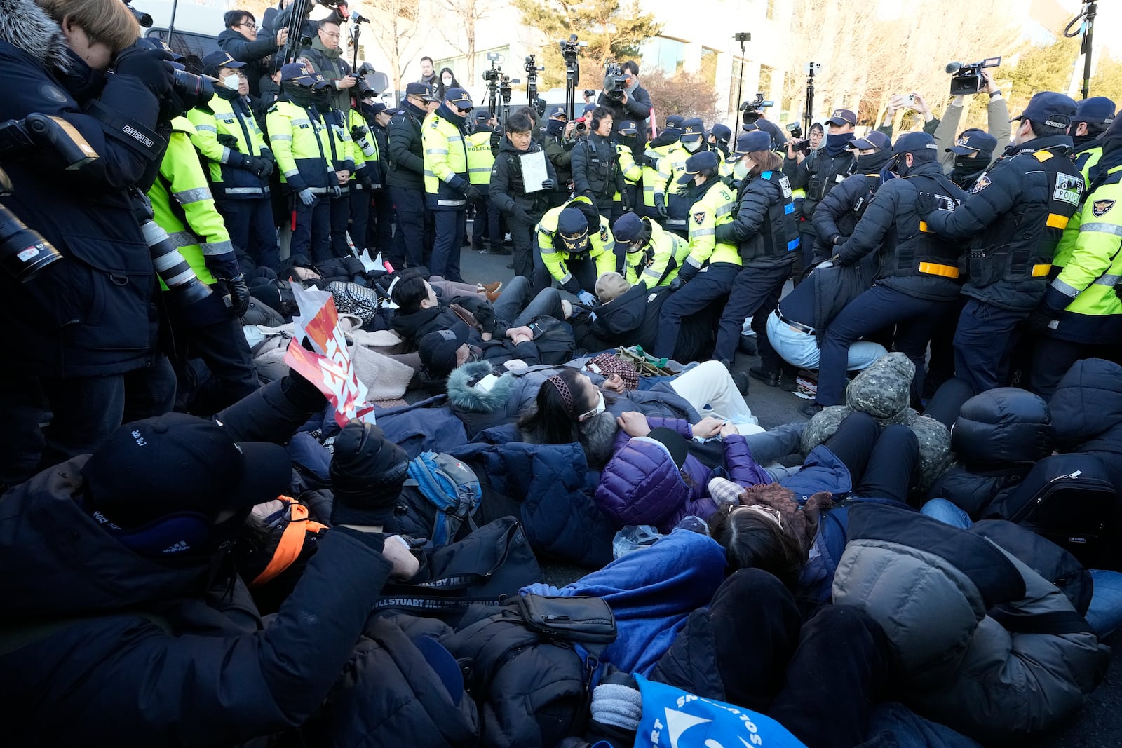 Police officers drag away supporters of impeached South Korean President Yoon Suk Yeol as Yoon faces potential arrest after a court on Tuesday approved a warrant for his arrest, near the presidential residence in Seoul, South Korea, Thursday, Jan. 2, 2025. (AP Photo/Ahn Young-joon)