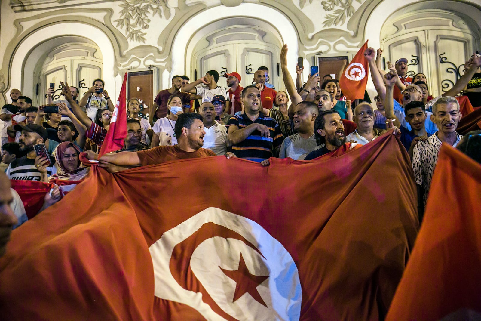 FILE - Tunisians celebrate the exit polls indicating a vote in favor of the new Constitution, in Tunis, on July 25, 2022. (AP Photo/Riadh Dridi, File)