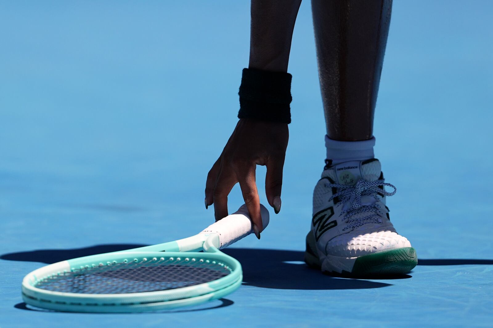 Coco Gauff of the U.S. picks her racket up during her quarterfinal match against Paula Badosa of Spain during their quarterfinal match at the Australian Open tennis championship in Melbourne, Australia, Tuesday, Jan. 21, 2025. (AP Photo/Ng Han Guan)