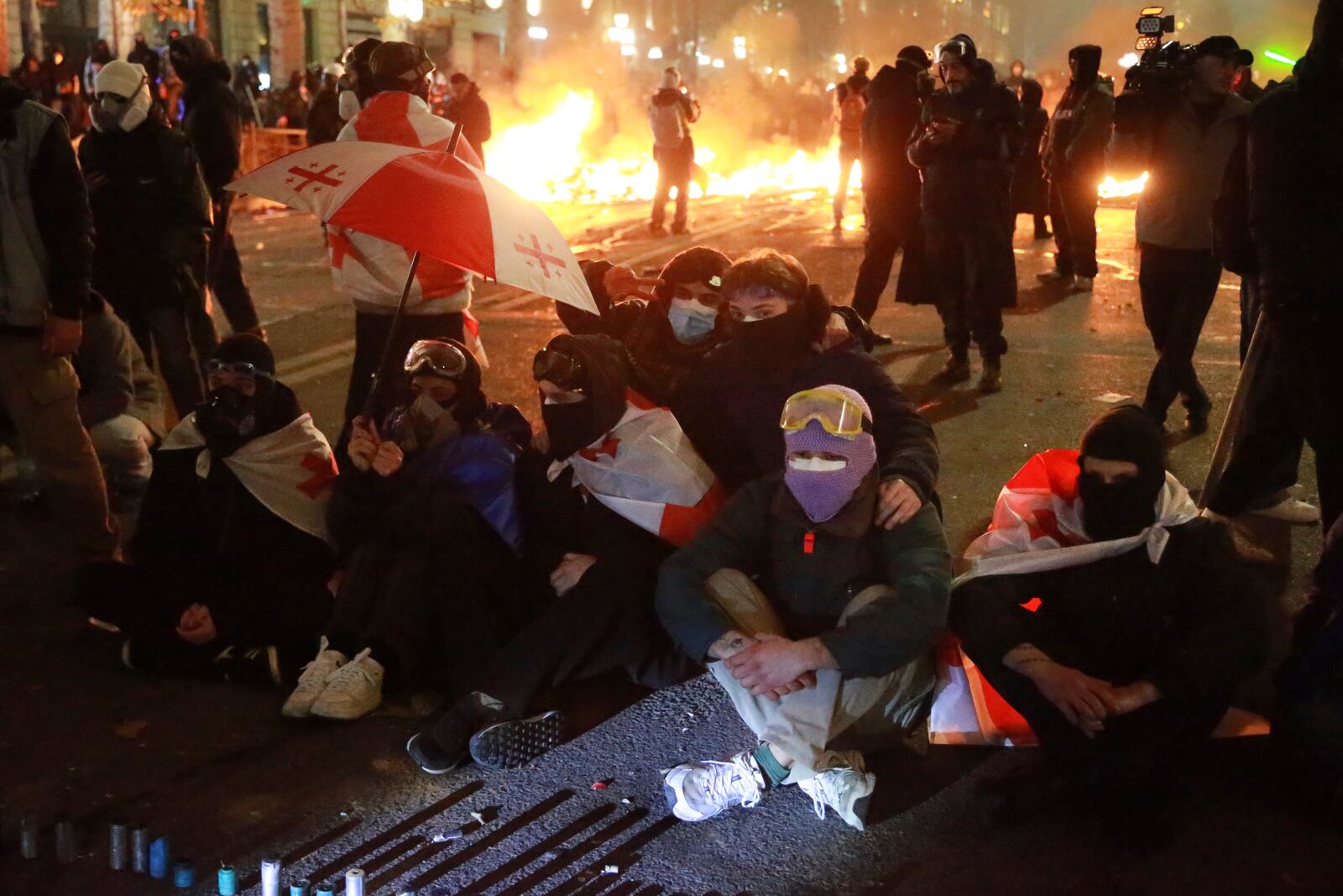 Demonstrators sit in front of police protesting against the government's decision to suspend negotiations on joining the European Union in Tbilisi, Georgia, early Tuesday, Dec. 3, 2024. (AP Photo/Zurab Tsertsvadze)