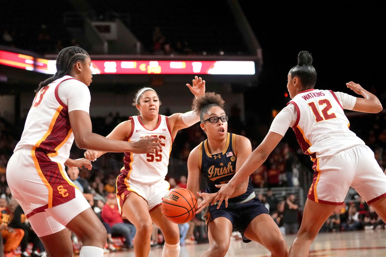 Notre Dame guard Olivia Miles passes around Southern California guard JuJu Watkins (12) as center Rayah Marshall (13) and guard Talia von Oelhoffen (55) defend during the first half of an NCAA college basketball game, Saturday, Nov. 23, 2024 in Los Angeles. (AP Photo/Eric Thayer)