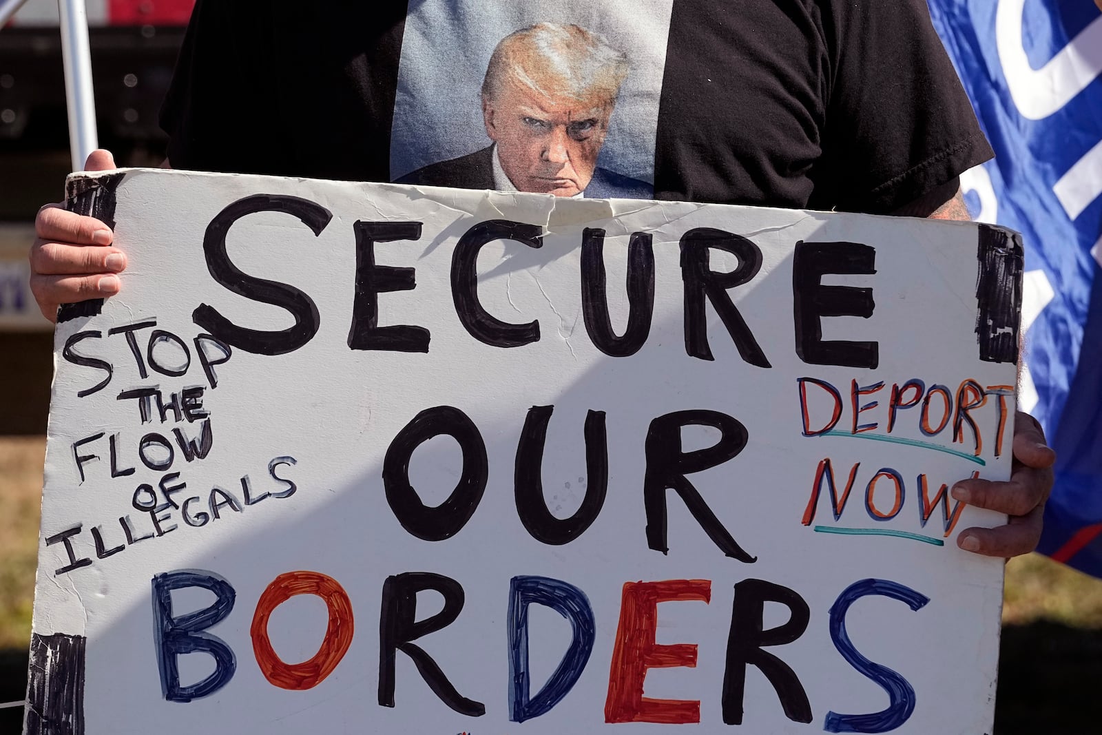 FILE - Phill Cady wears a t-shirt with a photo of former President Donald Trump, who is running for reelection, as he holds a sign during a "Take Our Border Back" rally on Feb. 3, 2024, in Quemado, Texas. (AP Photo/Eric Gay, File)