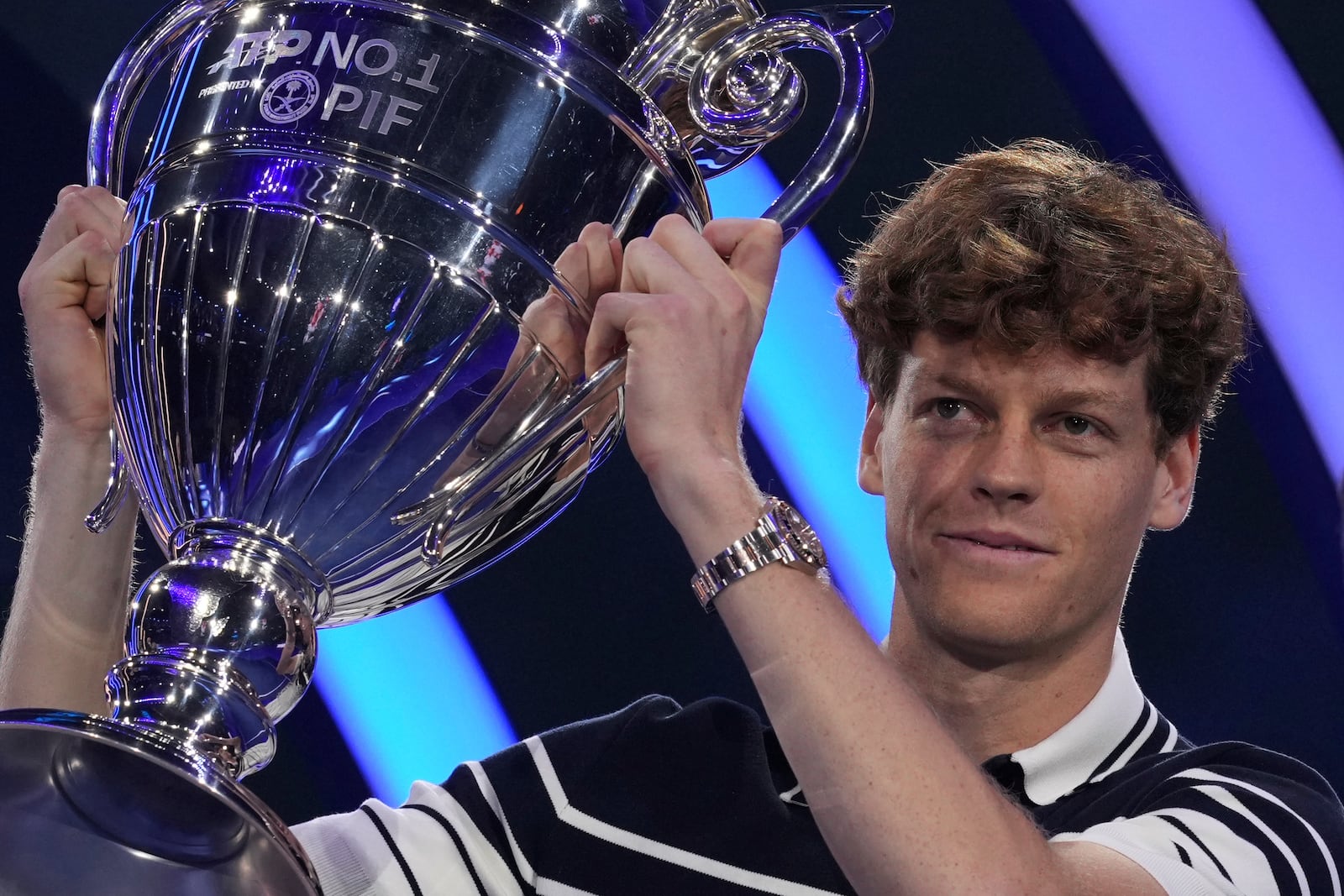 Italy's Jannik Sinner holds the trophy as ATP world best player at the ATP World Tour Finals at the Inalpi Arena, in Turin, Italy, Monday, Nov. 11, 2024. Sinner was presented with the trophy for finishing the year ranked No. 1. (AP Photo/Antonio Calanni)