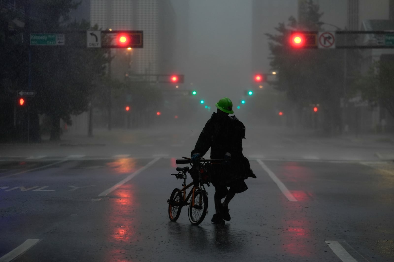 Ron Rook, who said he was looking for people in need of help or debris to clear, walks through windy and rainy conditions on a deserted street in downtown Tampa, Fla., during the approach of Hurricane Milton, Wednesday, Oct. 9, 2024. (AP Photo/Rebecca Blackwell)