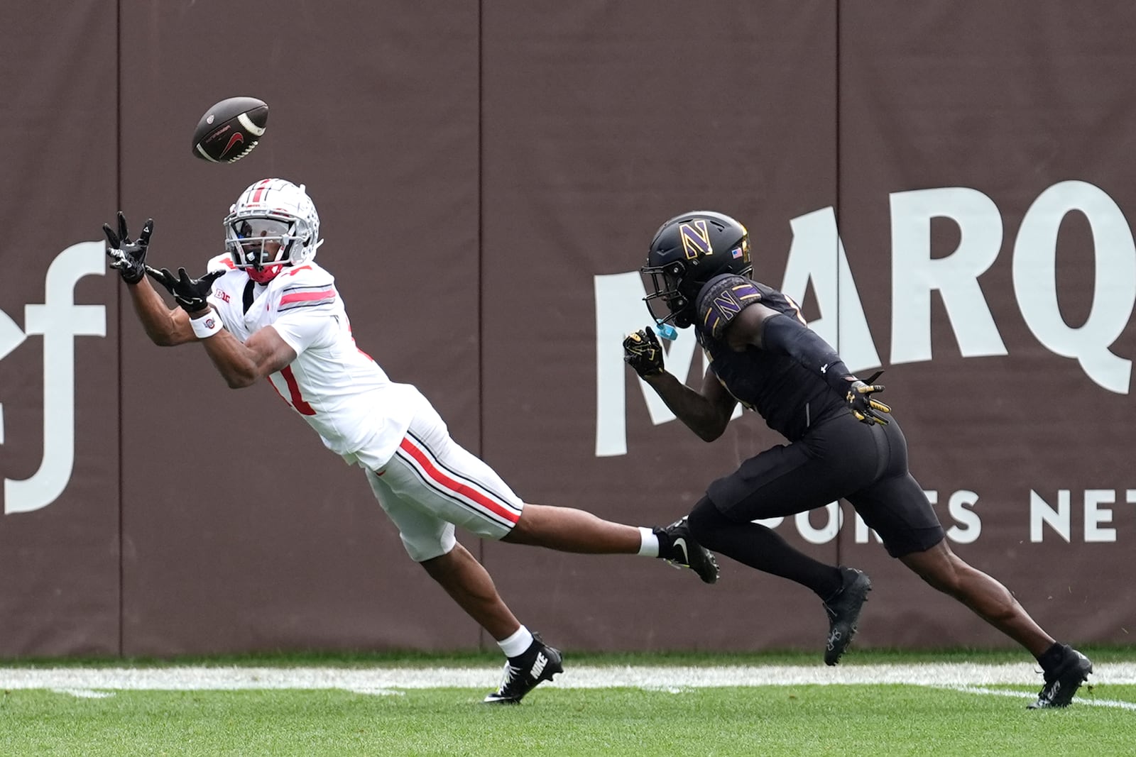 Ohio State wide receiver Carnell Tate State lays out for a touchdown pass as Northwestern defensive back Josh Fussell defends during the first half of an NCAA college football game at Wrigley Field on Saturday, Nov. 16, 2024, in Chicago. (AP Photo/Charles Rex Arbogast)