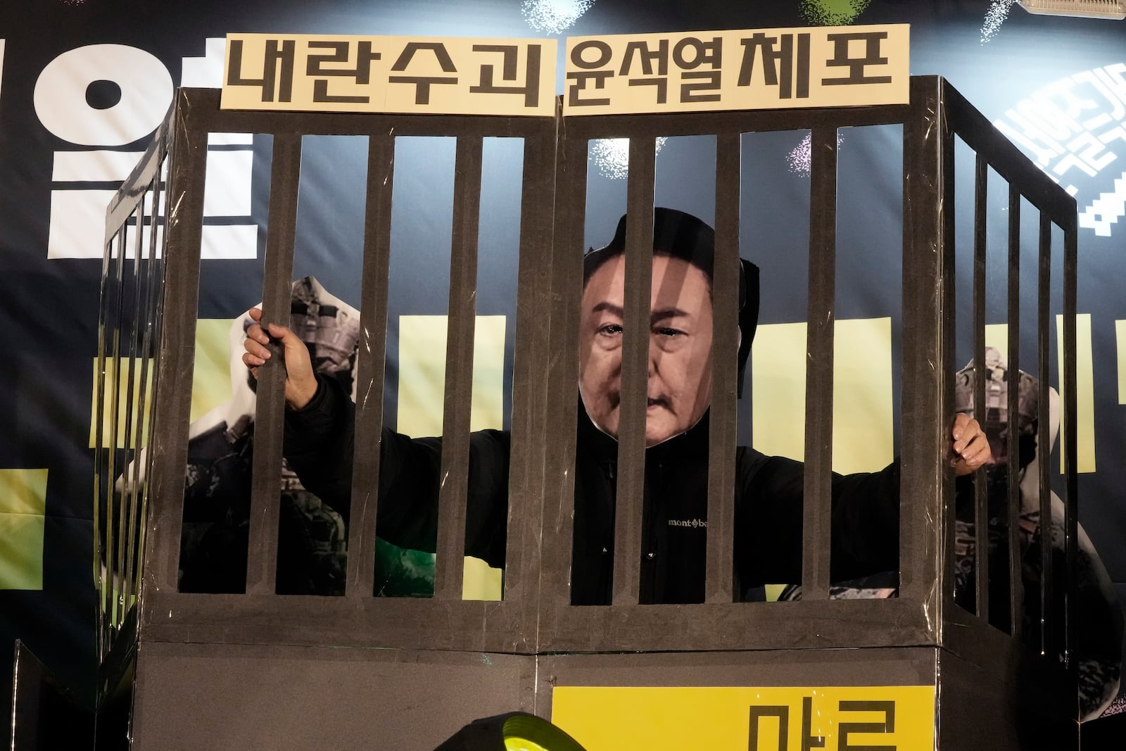 A participant wearing a mask of South Korean President Yoon Suk Yeol performs during a rally to demand his impeachment outside the National Assembly in Seoul, South Korea, Wednesday, Dec. 11, 2024. The signs read "Arrest the rebellion leader Yoon Suk Yeol." (AP Photo/Ahn Young-joon)