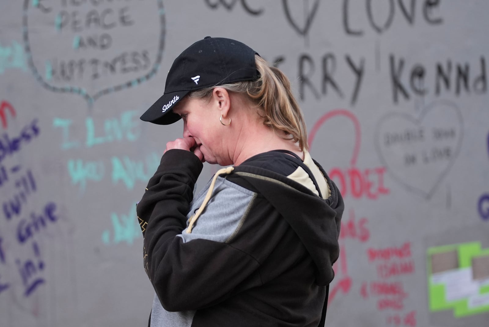 Alisa Kuhns, visiting from Santa Rosa, Calif. reacts at memorial on Bourbon Street for the victims of a deadly truck attack on New Year's Day in New Orleans, Friday, Jan. 3, 2025. (AP Photo/Gerald Herbert)