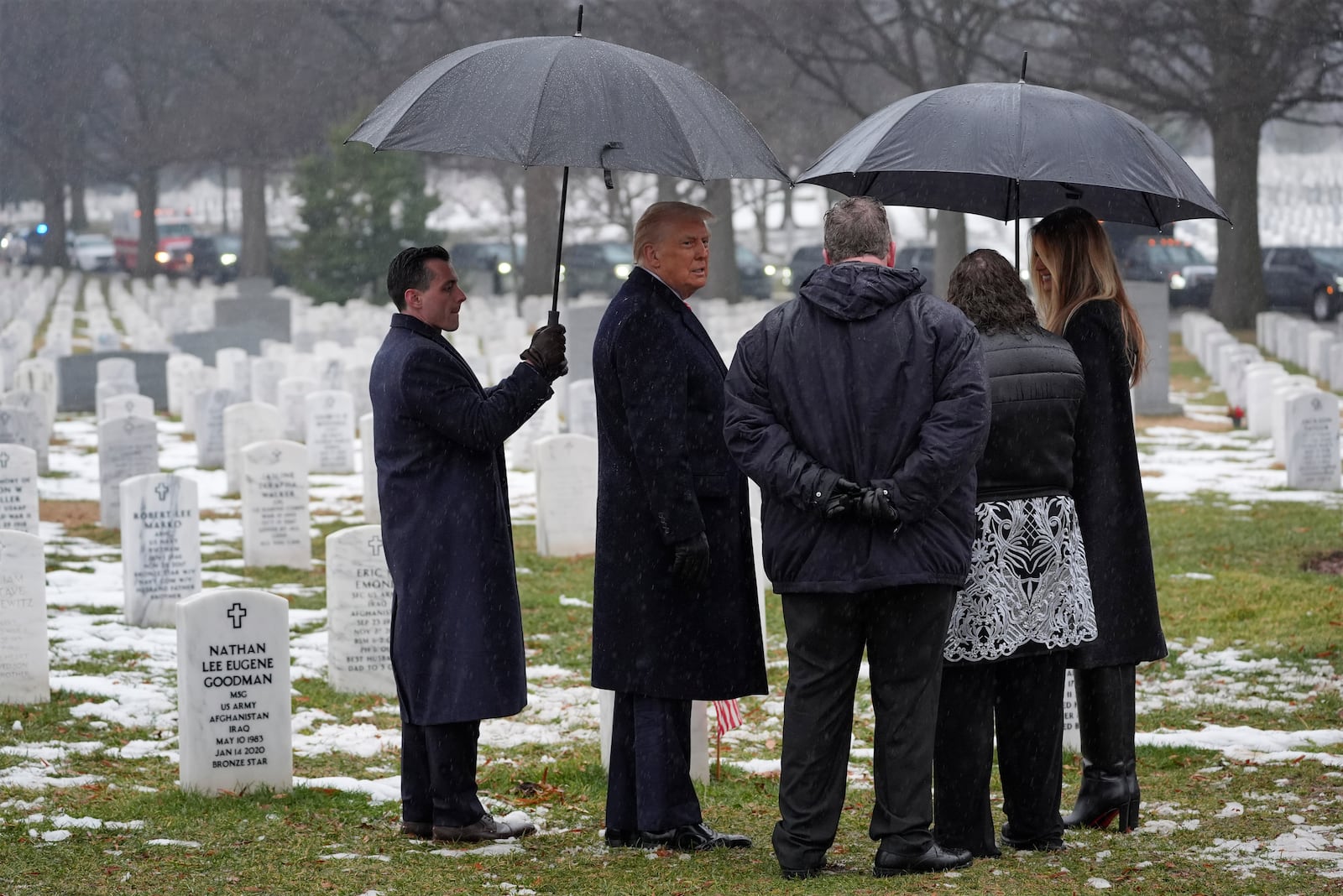 President-elect Donald Trump and Melina Trump talk with family members in Section 60 at Arlington National Cemetery, Sunday, Jan. 19, 2025, in Arlington, Va. (AP Photo/Evan Vucci)