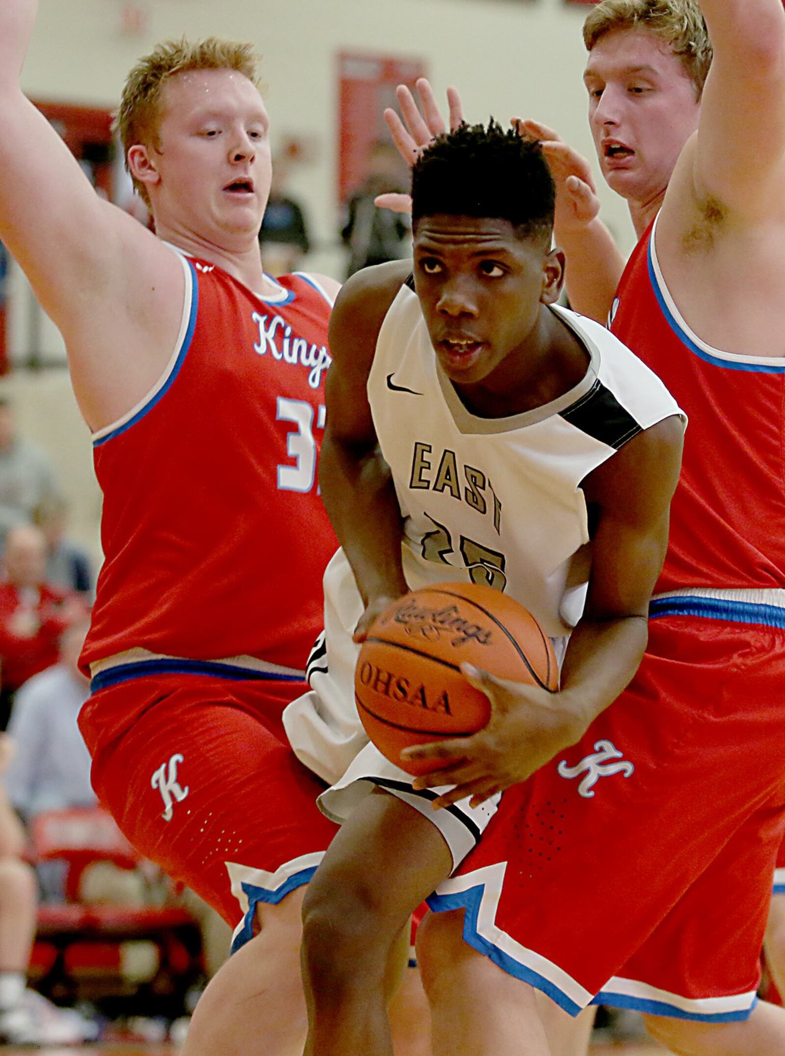 Lakota East forward Kyrell Metts moves between Kings’ Matt Sichterman (33) and Dan Sichterman (25) during their Division I sectional game at Lakota West on Wednesday night. CONTRIBUTED PHOTO BY E.L. HUBBARD