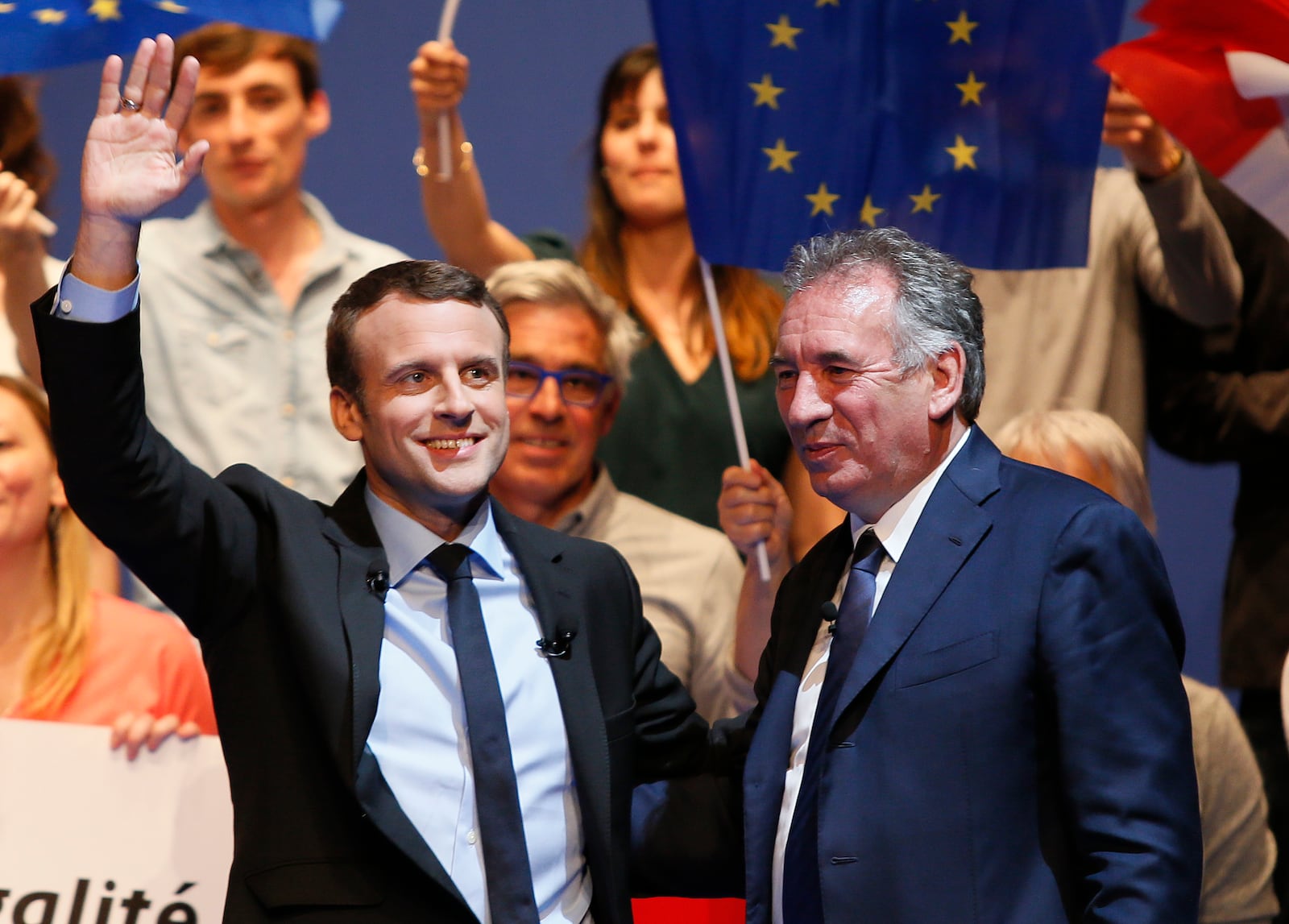 FILE - French centrist presidential election candidate Emmanuel Macron, left, waves supporters as French centrist politician Francois Bayrou looks on during a meeting in Pau, southwestern France, Wednesday, April 12, 2017. (AP Photo/Bob Edme, File)