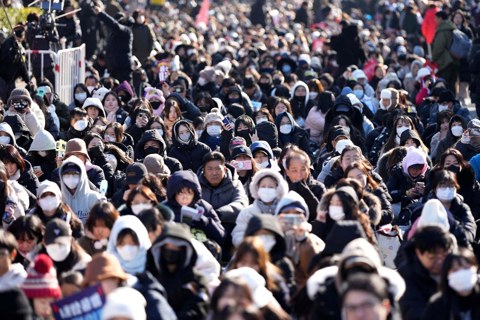 People wait before a rally to demand South Korean President Yoon Suk Yeol's impeachment outside the National Assembly in Seoul, South Korea, Saturday, Dec. 14, 2024. (AP Photo/Lee Jin-man)