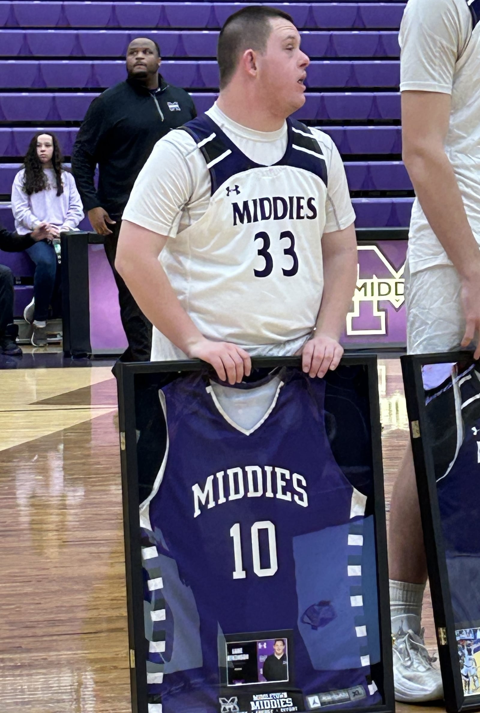 Senior Luke Atkinson, the boys basketball team manager at Middletown High School, received a framed jersey Tuesday night after the Middies beat Mason. All the seniors received framed jerseys. RICK McCRABB/STAFF