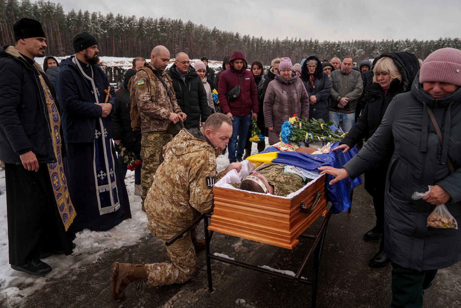 Ukrainian serviceman Roman bids farewell to his comrade of the 47th brigade Serhii Solovyov who was killed during fighting with Russian Forces in Kursk oblast on November 12, during the funeral ceremony in Irpin, Kyiv region, Ukraine, Nov. 21, 2024. (AP Photo/Evgeniy Maloletka)