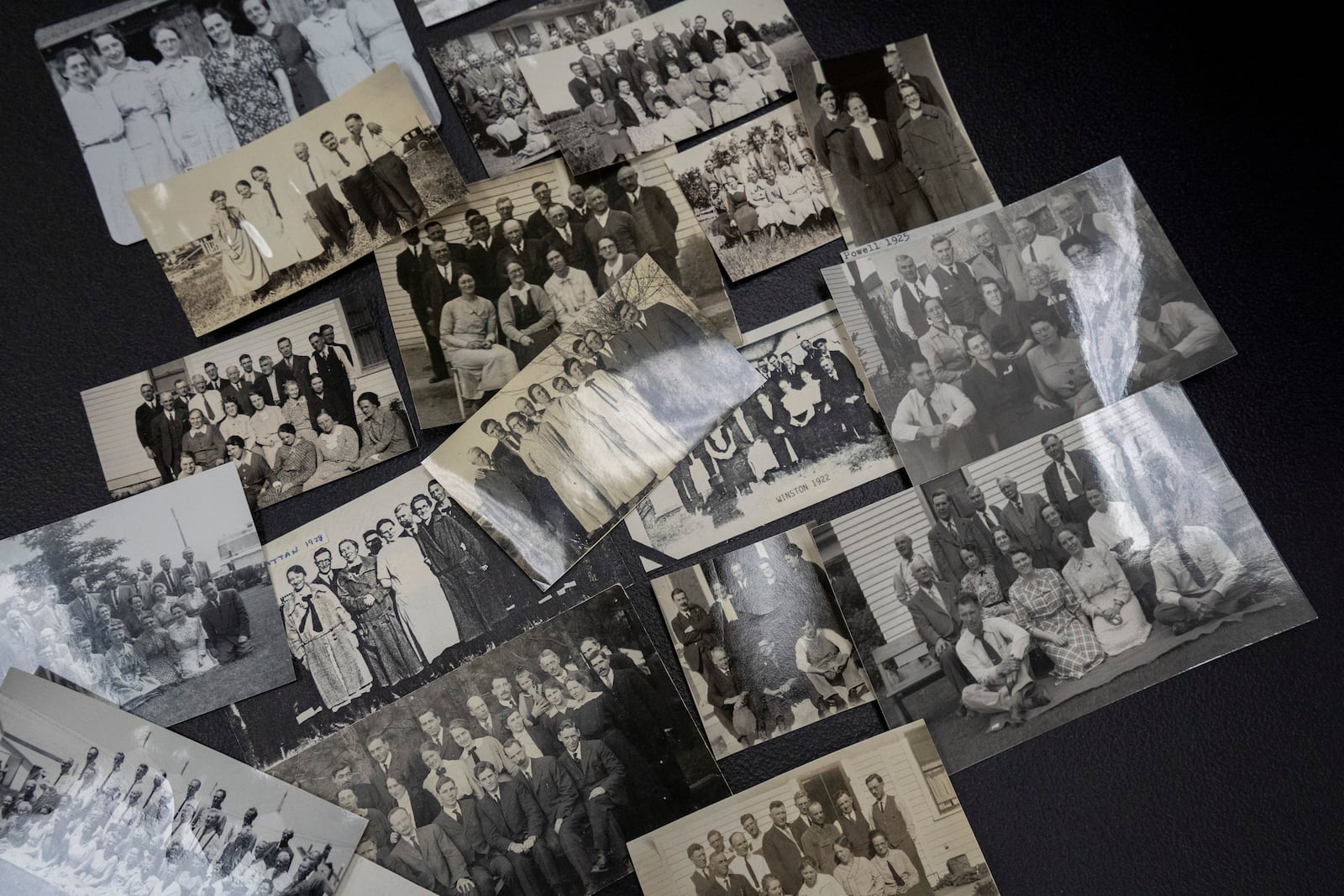 Photographs from annual “Two by Twos” sect conventions sit on a table at a library Monday, Dec. 9, 2024 in Wailea, Hawaii. Former sect member Pam Walton uses photos and other documents to track the movements of spiritual leaders facing child sex abuse allegations within the group. (AP Photo/Mengshin Lin)