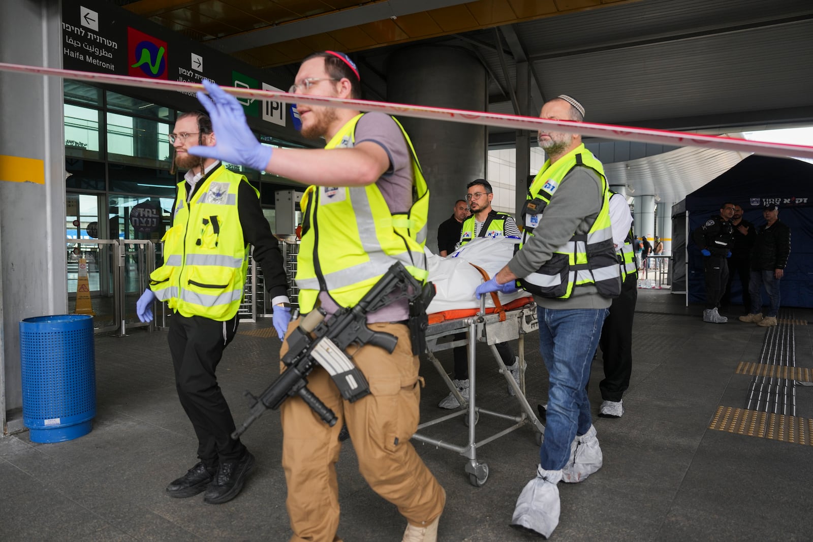 Members of ZAKA rescue services carry the body of a 70-year-old killed in stabbing attack in Haifa, Israel, on Monday, March 30, 2025. Four others were also injured in the incident. (AP Photo/Ariel Schalit)