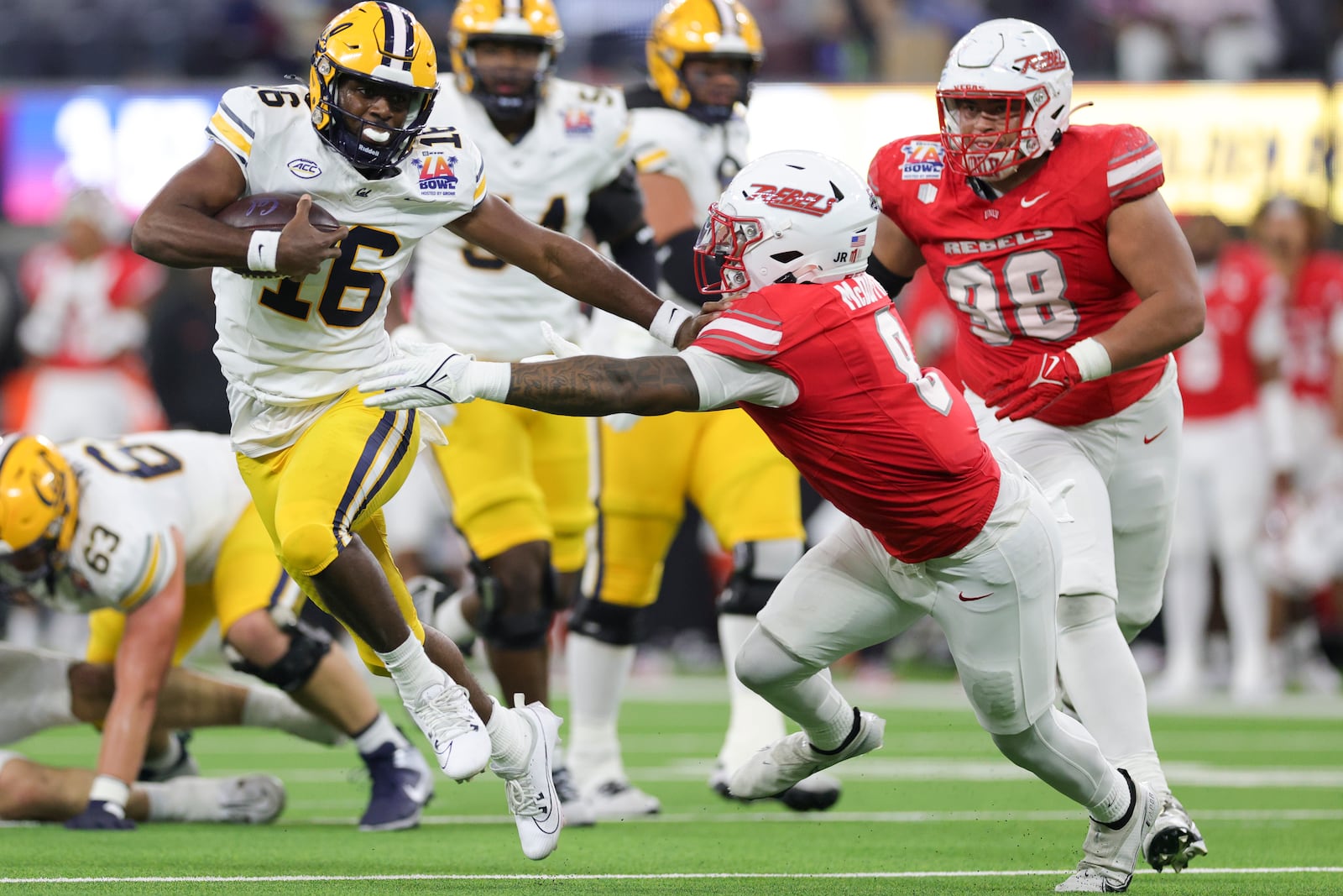 California quarterback CJ Harris, left, stiff arms UNLV linebacker Marsel McDuffie during the first half of the LA Bowl NCAA college football game Wednesday, Dec. 18, 2024, in Inglewood, Calif. (AP Photo/Ryan Sun)