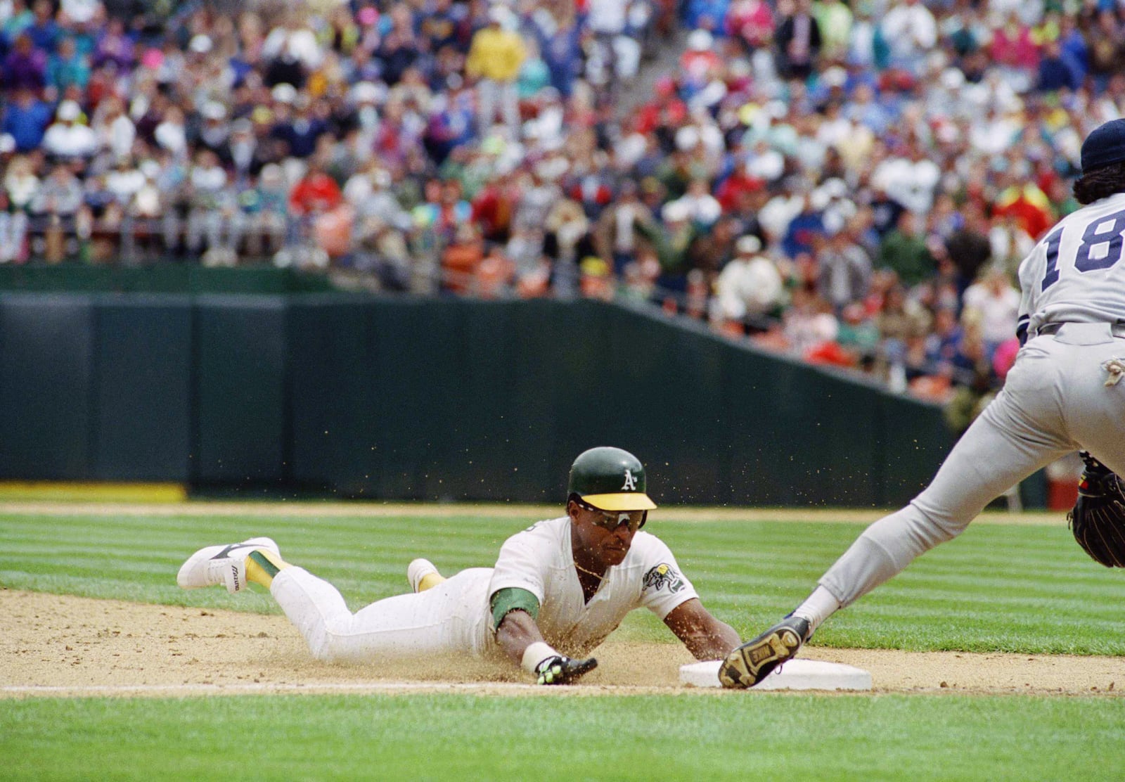 FILE - Oakland Athletics' Rickey Henderson, left, goes sliding into third base to steal his 939th career base to set a new all-time major league record during their game with the New York Yankees at Oakland, May 1, 1991. (AP Photo/Eric Risberg, File)