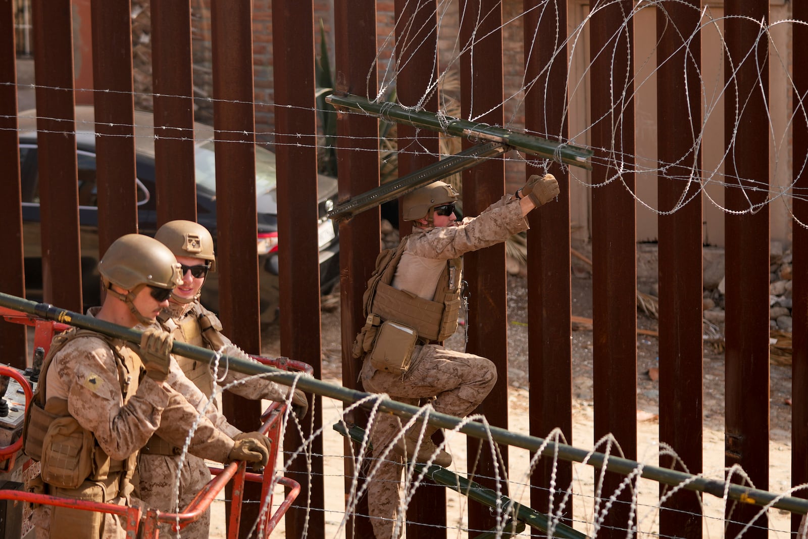 U.S. Marines install barbed wire along the border fence Friday, Jan. 31, 2025, in San Diego. (AP Photo/Jae C. Hong)