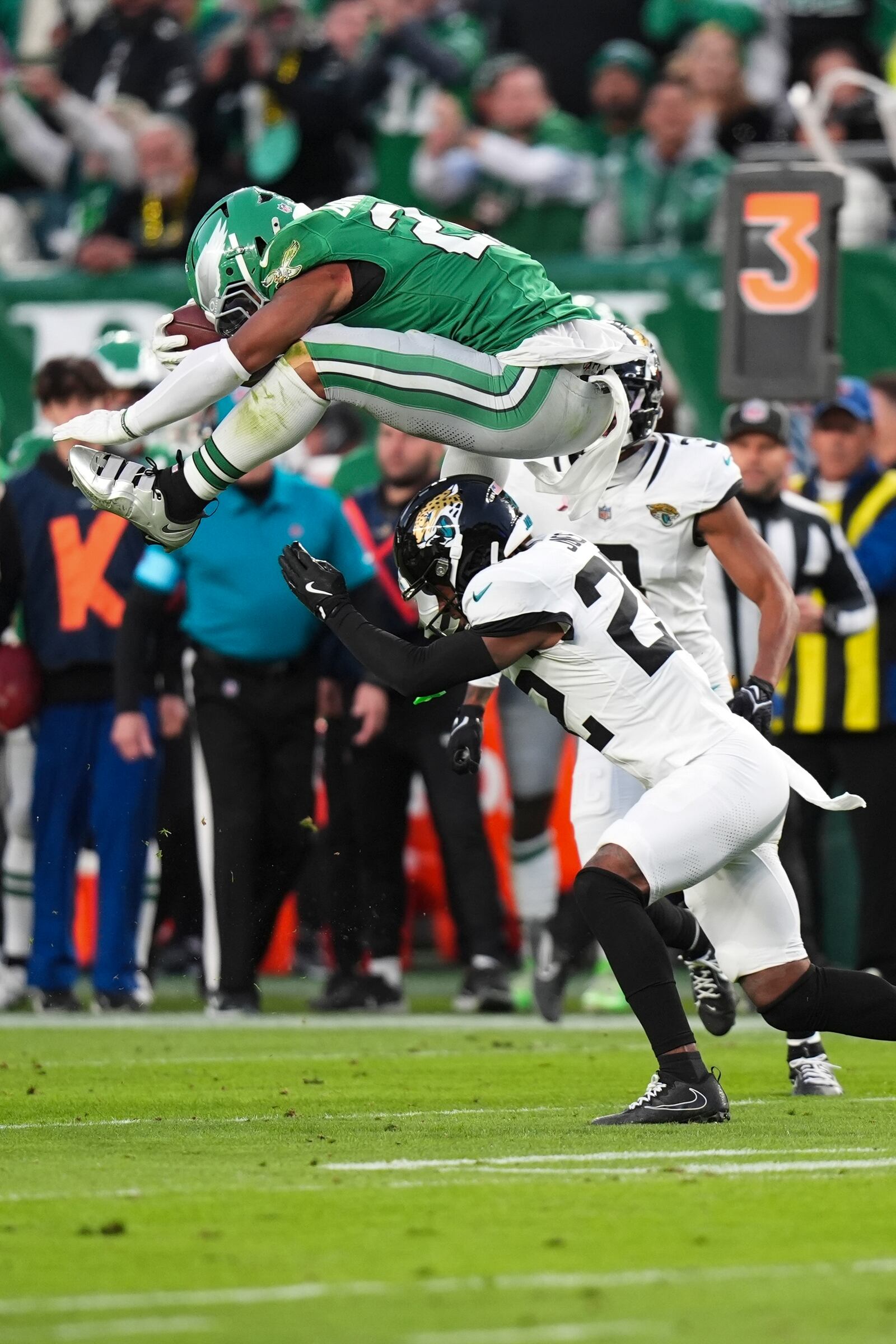 Philadelphia Eagles running back Saquon Barkley (26) leaps over Jacksonville Jaguars cornerback Jarrian Jones (22) during the first half of an NFL football game Sunday, Nov. 3, 2024, in Philadelphia. (AP Photo/Chris Szagola)