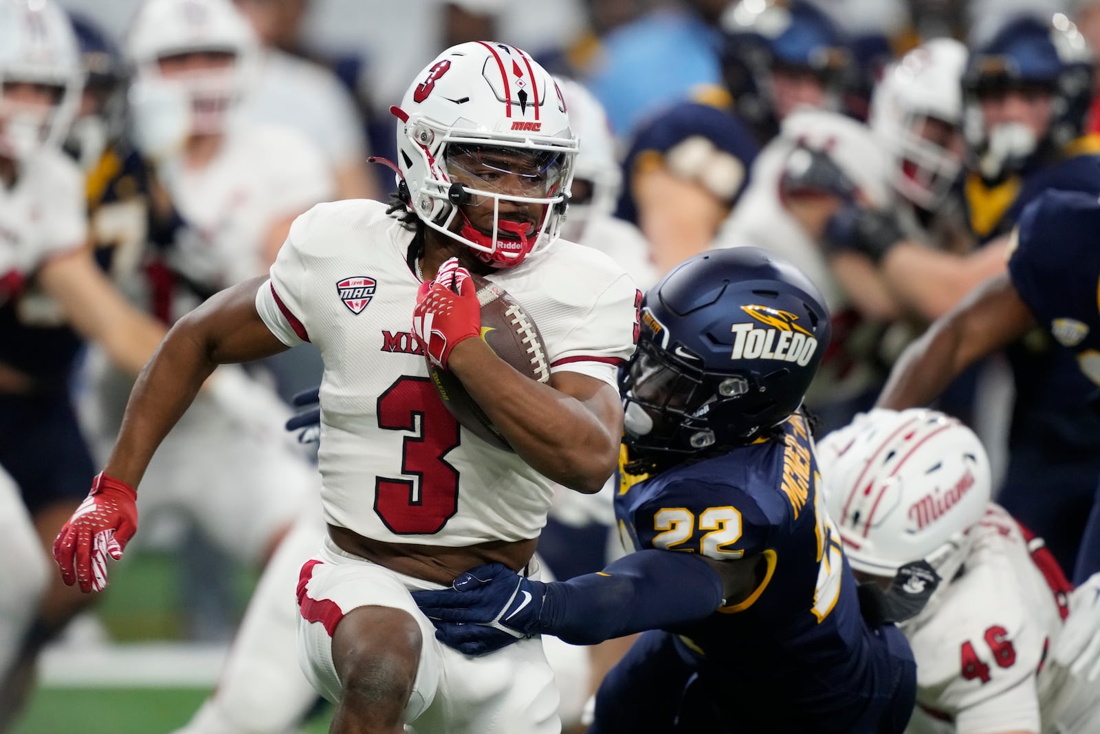 Miami (Ohio) running back Keyon Mozee (3) is tackled by Toledo safety Emmanuel McNeil-Warren (22) during the first half of the Mid-American Conference championship NCAA college football game, Saturday, Dec. 2, 2023, in Detroit. (AP Photo/Carlos Osorio)