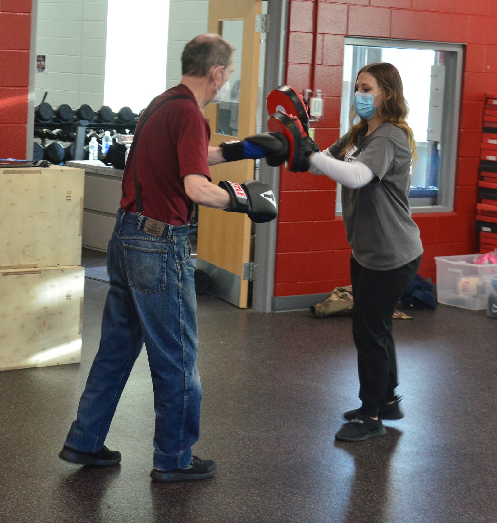 Savannah Doherty, right, uses the mitt targets for a Rock Steady Boxing program participant while backing up, requiring that he hit the targets as well as moving, first forward and then backward. CONTRIBUTED/BOB RATTERMAN