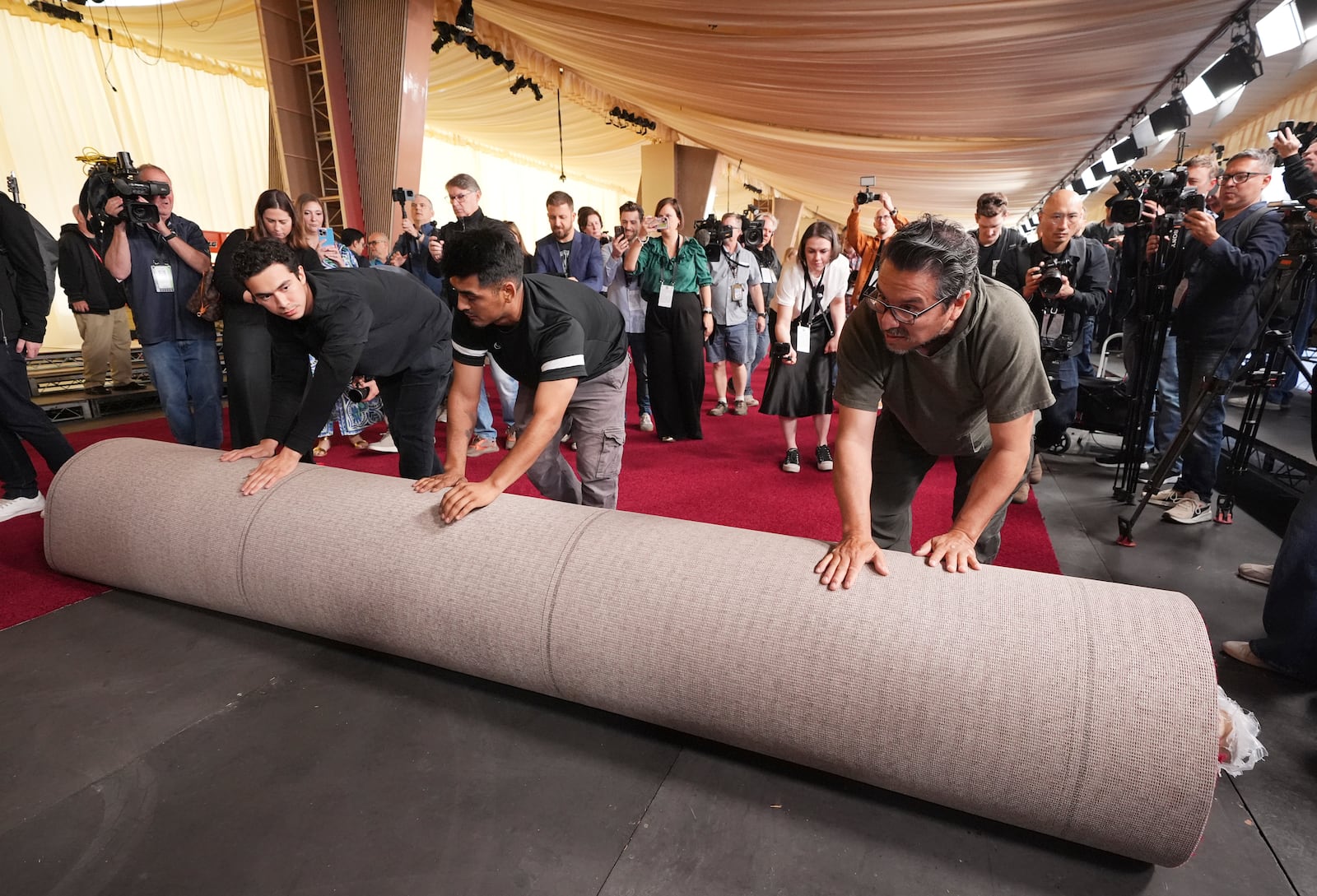 Crew members roll out the red carpet for Sunday's 97th Academy Awards at the Dolby Theatre on Wednesday, Feb. 26, 2025, in Los Angeles. (AP Photo/Chris Pizzello)