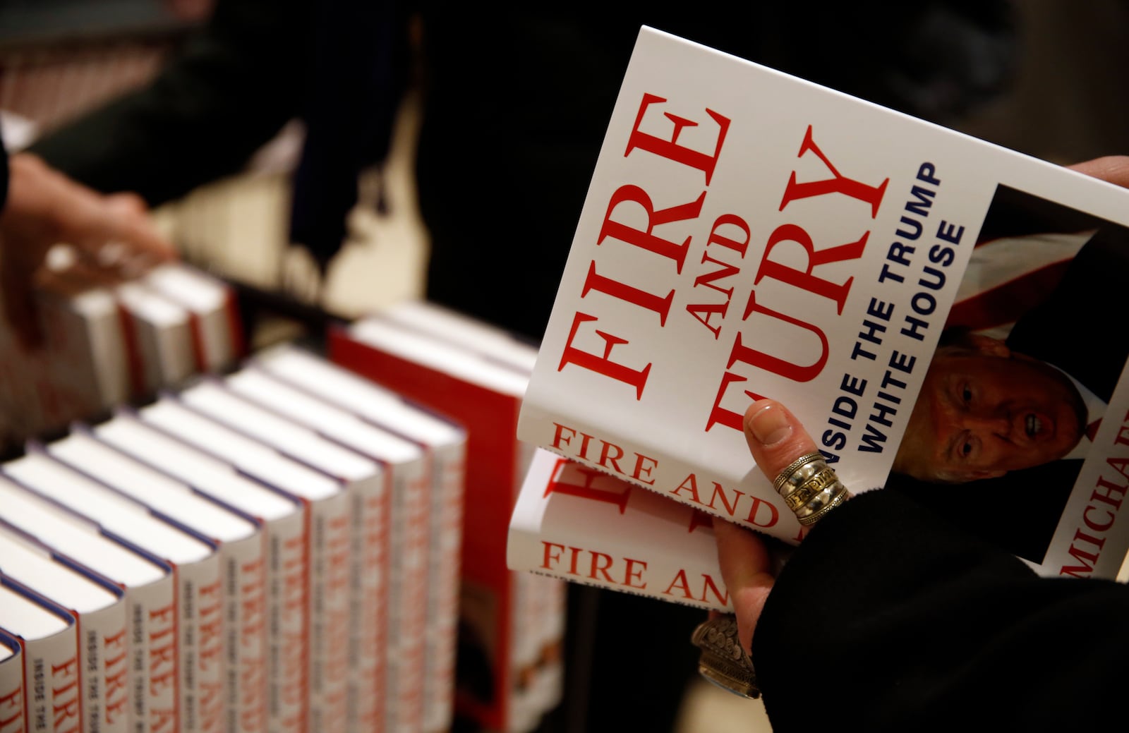 FILE - A customer looks at a copy of Michael Wolff's "Fire and Fury: Inside the Trump White House" as they go on sale at a bookshop, in London, Tuesday, Jan. 9, 2018. (AP Photo/Alastair Grant, File)