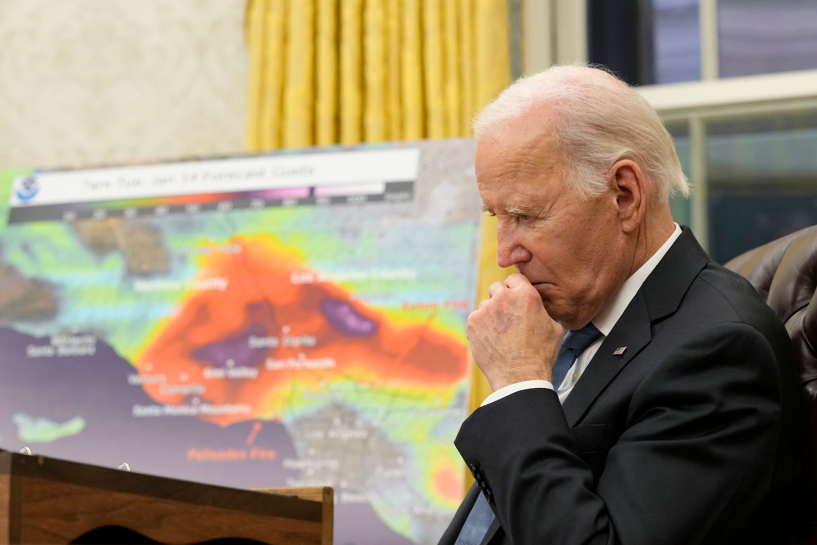 President Joe Biden listens during a meeting with senior officials as he is briefed on the federal response to the wildfires across Los Angeles during a meeting in the Oval Office of the White House in Washington, Monday, Jan. 13, 2025. The map in the background shows the projected wind speeds. (AP Photo/Susan Walsh)