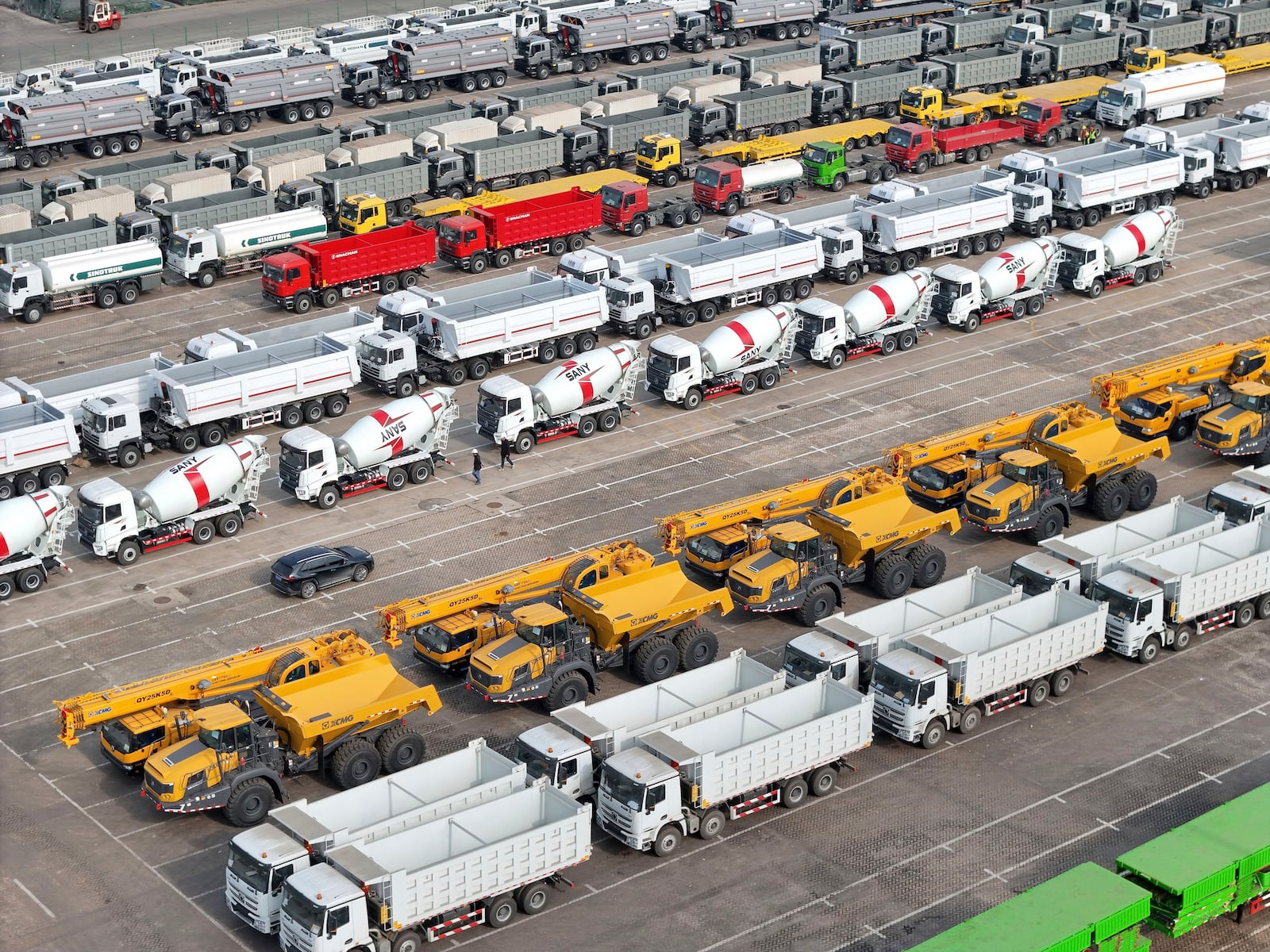 Trucks and engineering vehicles for export wait for transportation from a port in Yantai in eastern China's Shandong province Tuesday, Nov. 19, 2024. (Chinatopix Via AP)