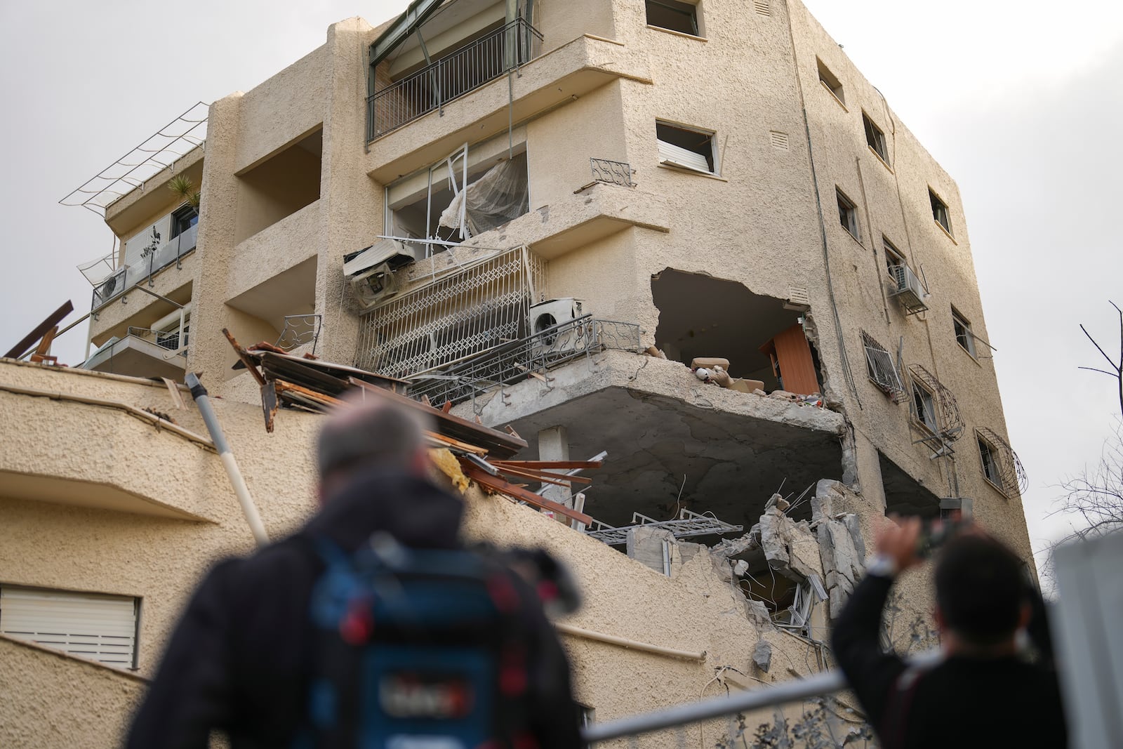 Journalists take pictures of a building hit direct by a rocket fired from Lebanon in Haifa, Israel, Sunday Nov. 24, 2024. (AP Photo/Francisco Seco)