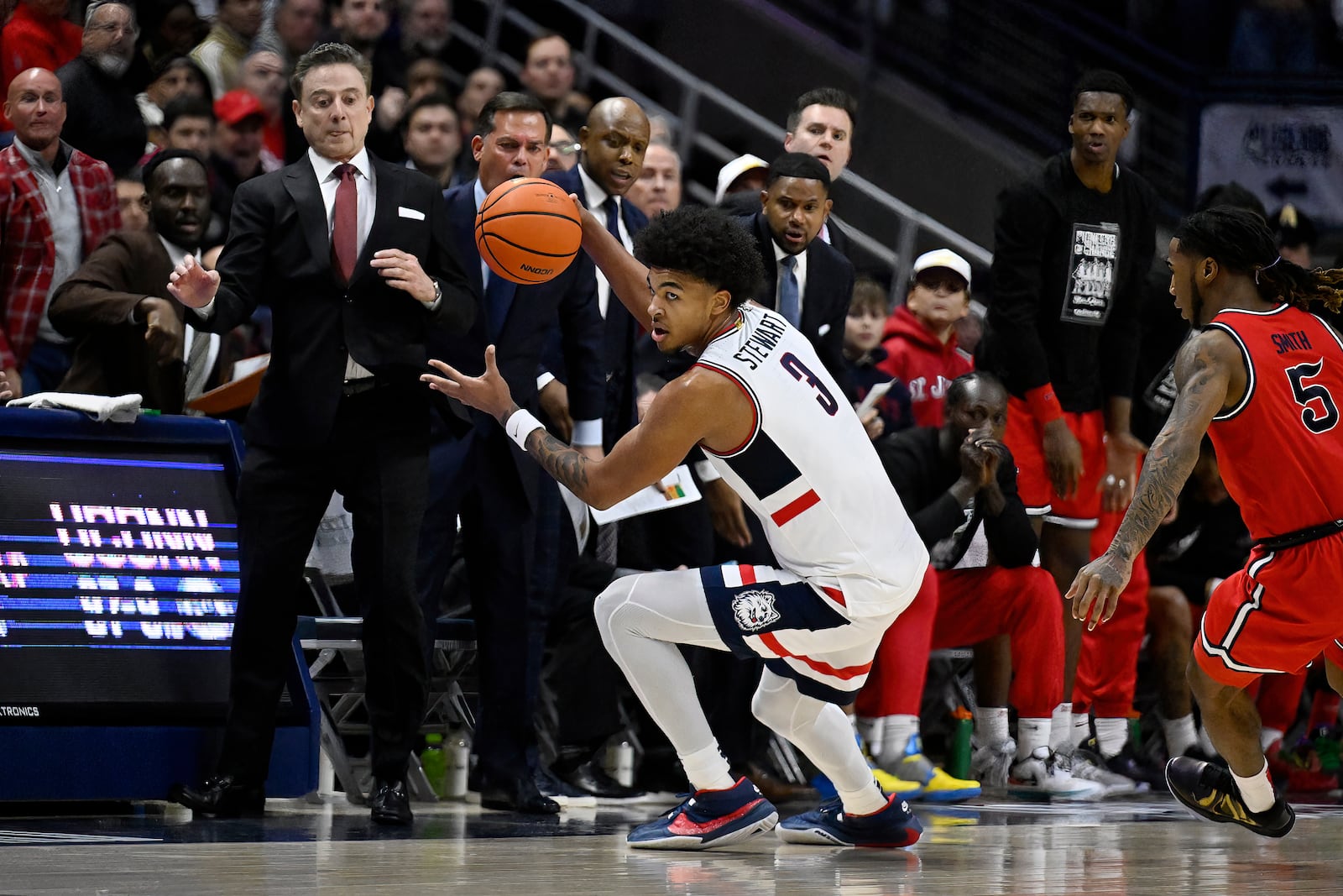 UConn forward Jaylin Stewart (3) catches a cross-court pass near St. John's head coach Rick Pitino, left, in the first half of an NCAA college basketball game, Friday, Feb. 7, 2025, in Storrs, Conn. (AP Photo/Jessica Hill)