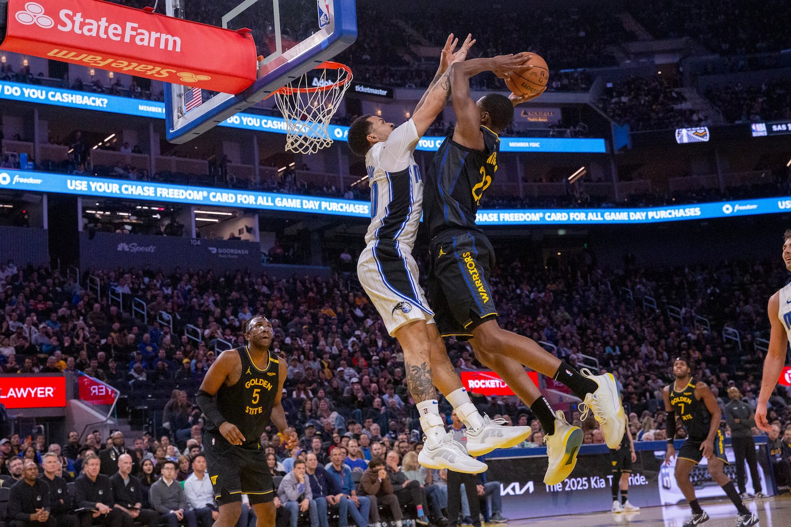 Golden State Warriors' Andrew Wiggins jumps to drunk the ball as Orlando Magic's Cole Anthony tries to block him during an NBA game at the Chase Center in San Francisco on Monday, Feb. 3, 2025. (Dan Hernandez/San Francisco Chronicle via AP)