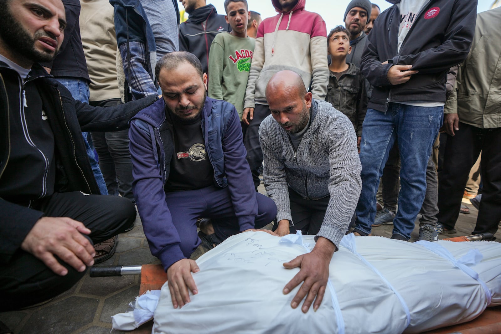 Palestinians prepare the body for the funeral of a man killed during an Israeli army strike in Deir al-Balah in the central Gaza Strip, Thursday Jan. 2, 2025. The strike killed at least eight men members of local committees that help secure aid convoys, according to the Al-Aqsa Martyrs Hospital, which received the bodies.(AP Photo/Abdel Kareem Hana)