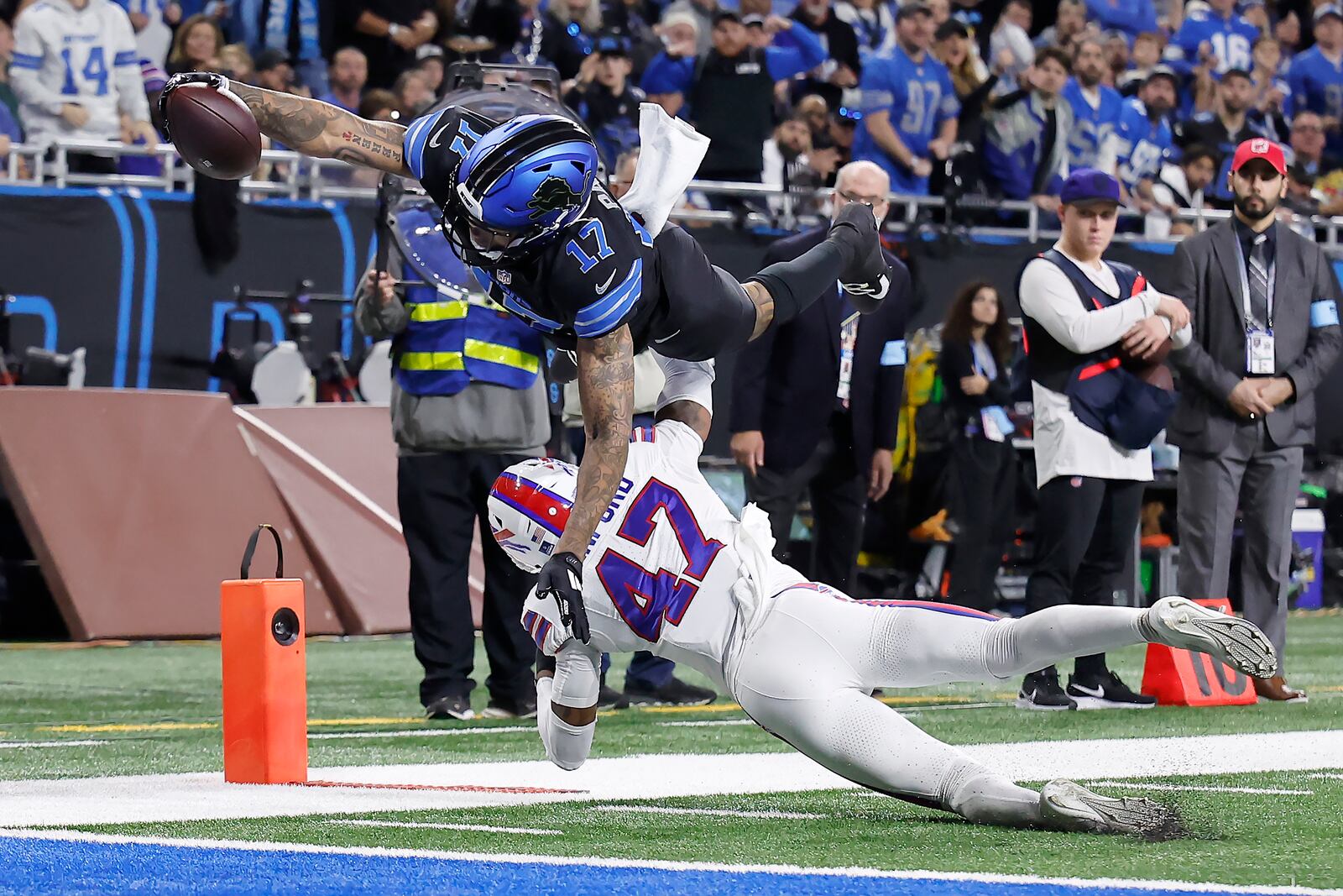 Detroit Lions wide receiver Tim Patrick (17) dives over Buffalo Bills cornerback Christian Benford (47) to score during the first half of an NFL football game, Sunday, Dec. 15, 2024, in Detroit. (AP Photo/Rey Del Rio)