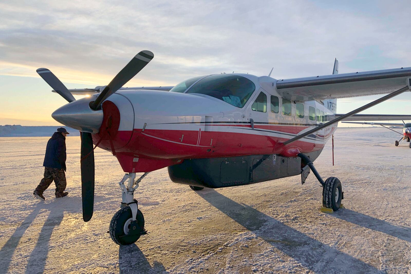 FILE - This Jan. 18, 2020, photo shows people preparing to get on a Ravn Connect airplane at the airport in Bethel, Alaska, for a flight to Toksook Bay. (AP Photo/Mark Thiessen, File)