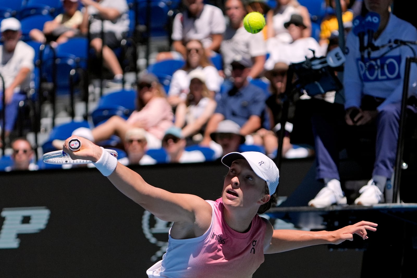 Iga Swiatek of Poland plays a backhand return to Emma Raducanu of Britain during their third round match at the Australian Open tennis championship in Melbourne, Australia, Saturday, Jan. 18, 2025. (AP Photo/Asanka Brendon Ratnayake)