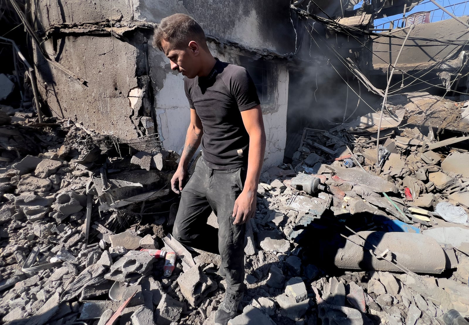 A man walks at the site of Israeli airstrikes that destroyed buildings facing the city's main government hospital in a densely-populated neighborhood, in southern Beirut, Lebanon, Tuesday, Oct. 22, 2024.(AP Photo/Hussein Malla)w