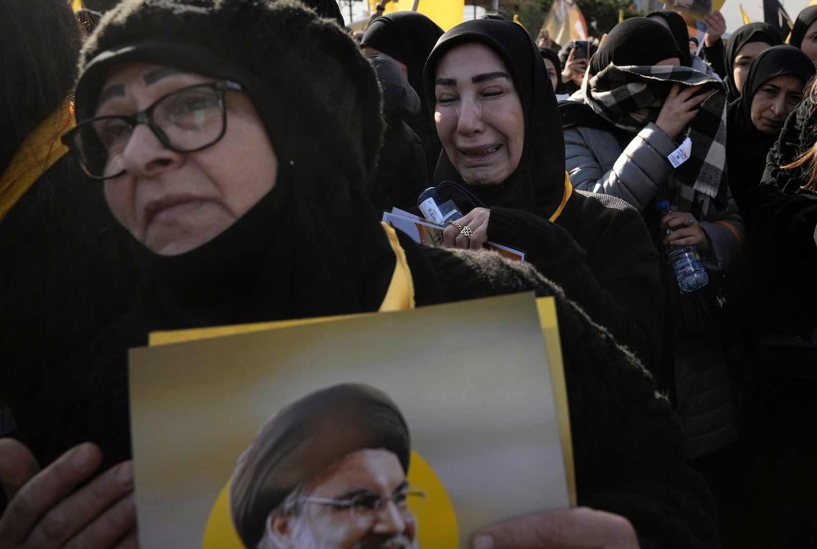 Mourners hold pictures of Lebanon's former Hezbollah leaders, Hassan Nasrallah and Hashem Safieddine, as they gather to attend their funeral procession in Beirut, Lebanon, Sunday Feb. 23, 2025. (AP Photo/Bilal Hussein)