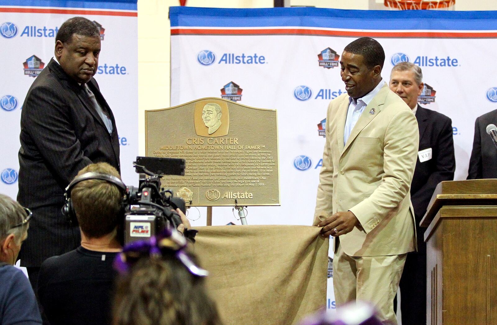 Cris Carter (right) and his brother Butch unveil a NFL Hall of Fame plaque during Carter’s visit Tuesday to Middletown High School.