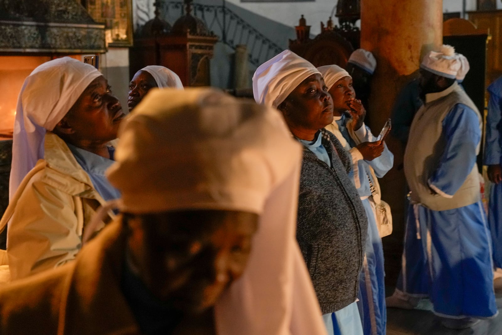 Nigerian worshippers pray in the Church of the Nativity, traditionally believed to be the birthplace of Jesus, on Christmas Eve, in the West Bank city of Bethlehem, Tuesday, Dec. 24, 2024. (AP Photo/Matias Delacroix)