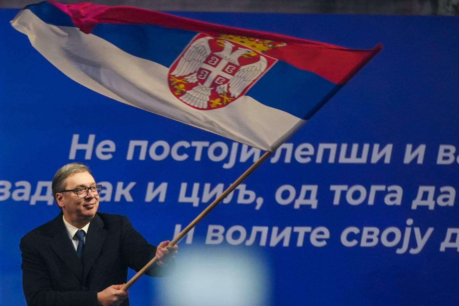 Serbian President Aleksandar Vucic waves a Serbian flag after a rally in a central town of Jagodina, Serbia, to counter the persistent anti-government protests, Friday, Jan. 24, 2025. (AP Photo/Antonio Ahel)