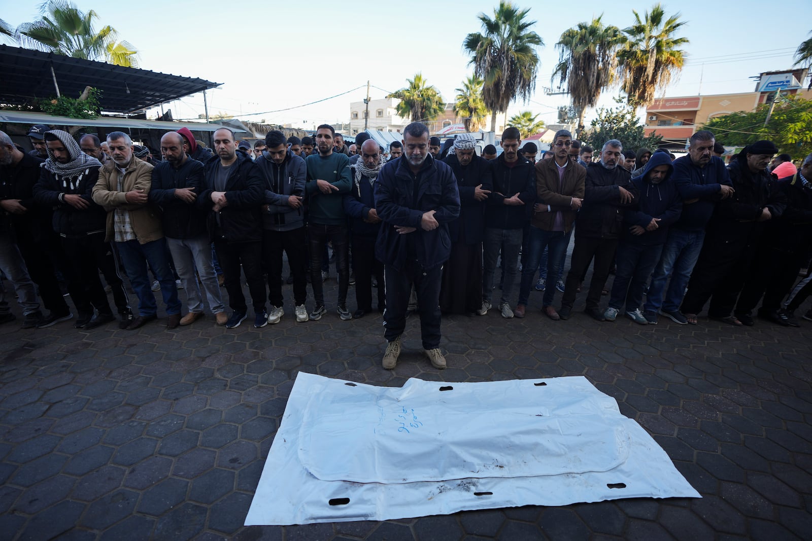 Palestinians pray before the funeral of a victim of an overnight Israeli strike, outside a hospital in Deir al-Balah, Gaza Strip, Wednesday, Dec. 4, 2024. (AP Photo/Abdel Kareem Hana)