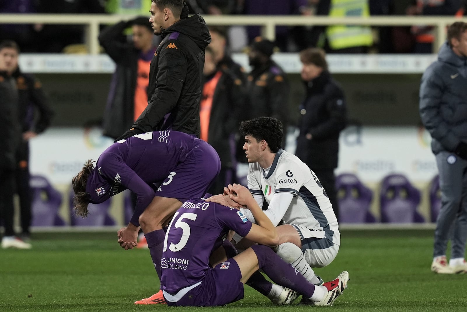 Emotional players comfort each other as Fiorentina's Edoardo Bove, injured, is taken to hospital during the Serie A soccer match between Fiorentina and Inter at the Artemio Franchi Stadium in Florence, Italy, Sunday Dec. 1, 2024. The match was suspended and finally postponed. (Massimo Paolone/LaPresse via AP)