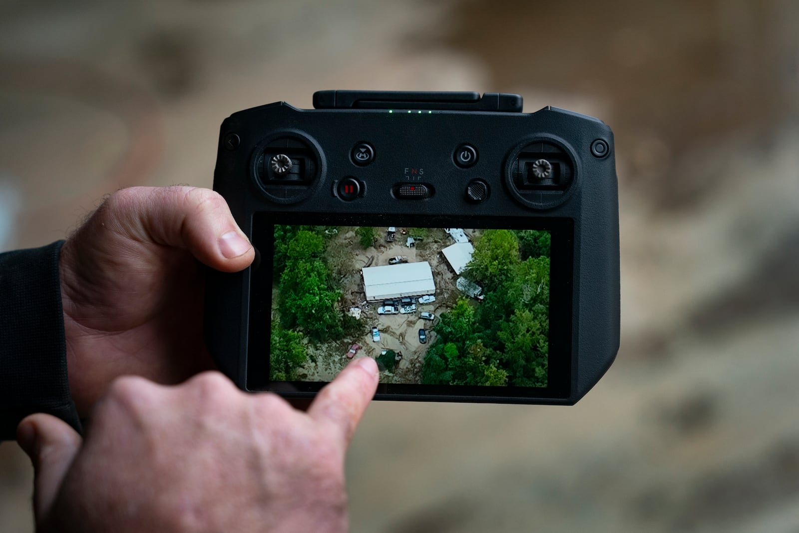 Russell Hedrick shows footage of when he used his drone to drop supplies to people during Hurricane Helene recovery, Tuesday, Dec. 17, 2024, in Hickory, N.C. (AP Photo/Allison Joyce)