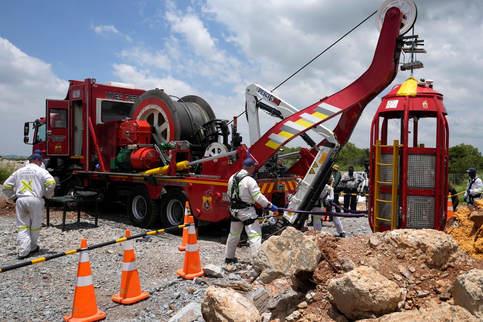 Mine rescue workers host up a cage that was used to rescue trapped miners at an abandoned gold mine, where miners were rescued from below ground, in Stilfontein, South Africa, Thursday, Jan. 16, 2025. (AP Photo/Themba Hadebe)