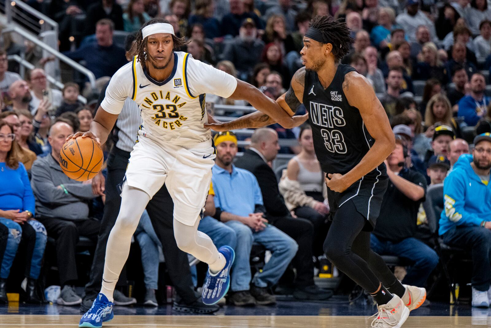 Indiana Pacers center Myles Turner (33) is defended by Brooklyn Nets center Nic Claxton (33) during the second half of an NBA basketball game in Indianapolis, Saturday, March 22, 2025. (AP Photo/Doug McSchooler)