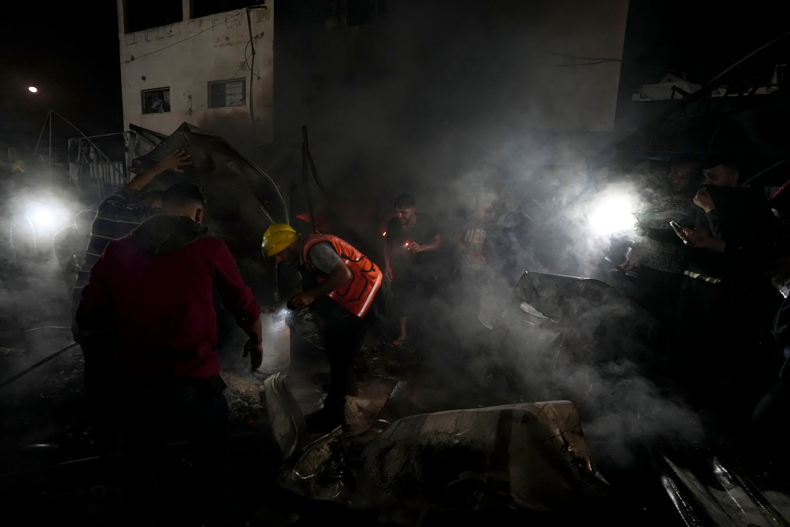 Palestinian firefighters try to extinguish a fire caused by an Israeli strike that hit a tent area in the courtyard of Al Aqsa Martyrs hospital in Deir al Balah, Gaza Strip, Monday, Oct. 14, 2024. (AP Photo/Abdel Kareem Hana)