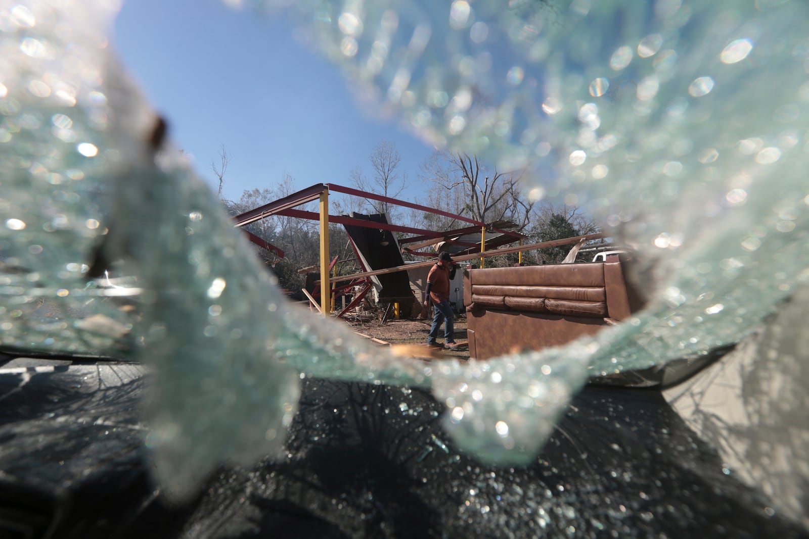 A man walks though debris in Conroe, Texas, Monday, Dec. 30, 2024, following a strong weekend storm system that spawned hail, rain, high winds and tornadoes across the southern U.S. (AP Photo/Lekan Oyekanmi)