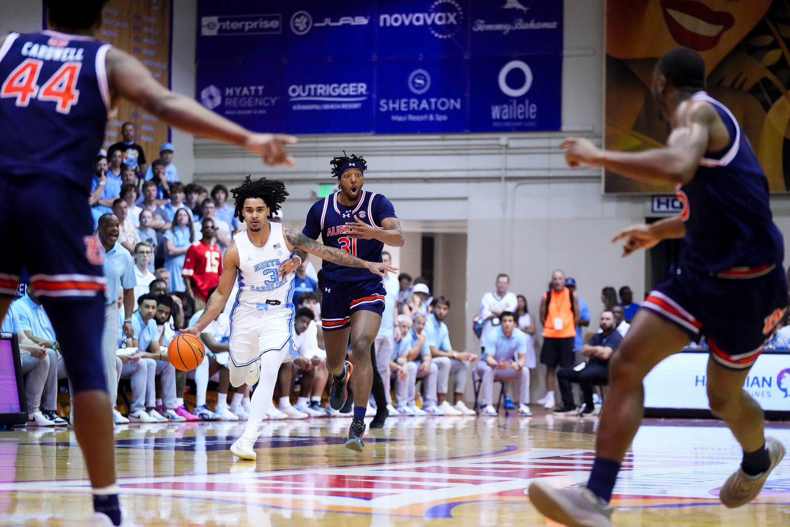 Auburn forward Chaney Johnson (31) reacts while guarding North Carolina guard Elliot Cadeau (3) during the first half of an NCAA college basketball game at the Maui Invitational Tuesday, Nov. 26, 2024, in Lahaina, Hawaii. (AP Photo/Lindsey Wasson)